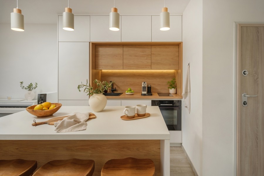 Isola cucina con mobili bianchi e in legno