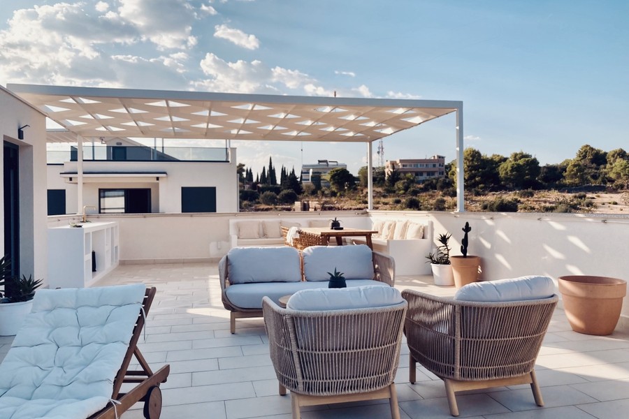 Terrazza sul tetto con pergola e zona salotto