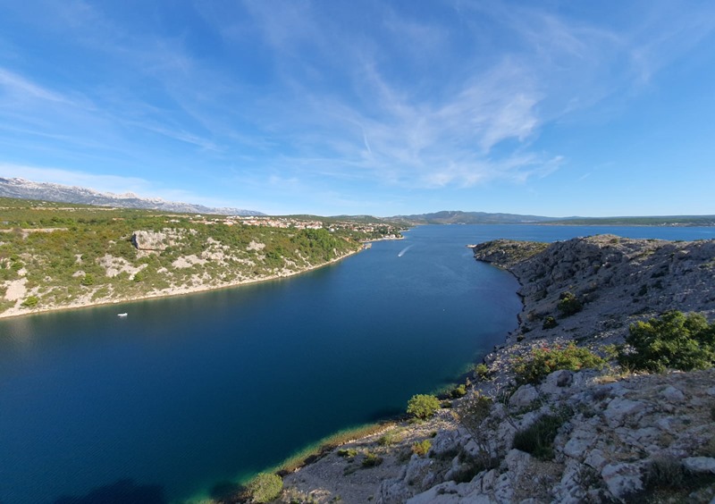 Vista dalla roccia sul canale, sul paese e sul Carso