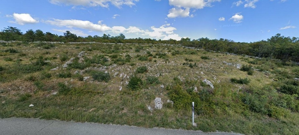 Prato carsico con massi sul ciglio della strada