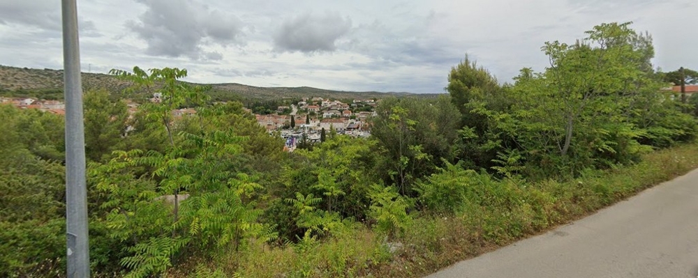 Terreno con vegetazione lungo la strada con vista sul paese