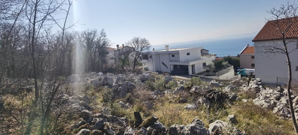 Terreno edificabile roccioso con vista sulla casa vicina e sul mare