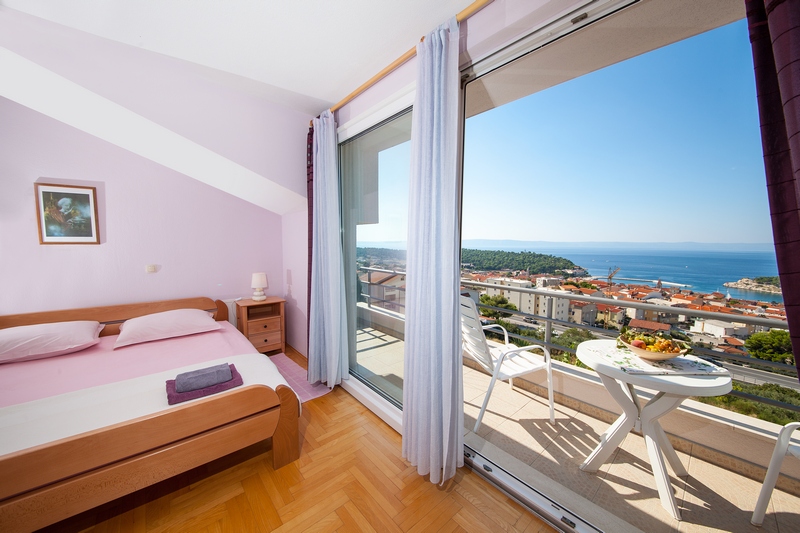 Camera da letto con balcone e splendida vista su Makarska e sul mare.