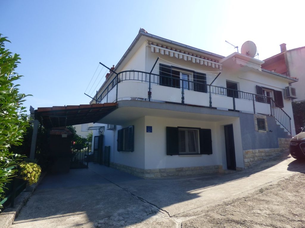 Casa con balcone perimetrale e carport all'ingresso