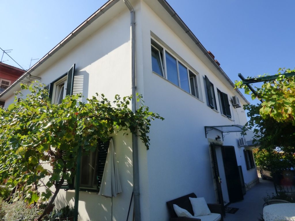 Angolo della casa con pergolato di vite e panca all'ingresso