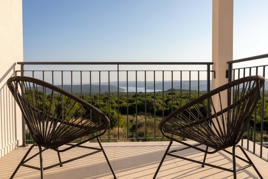 Balcone con sedie in filo metallico e ampia vista sulla boscaglia