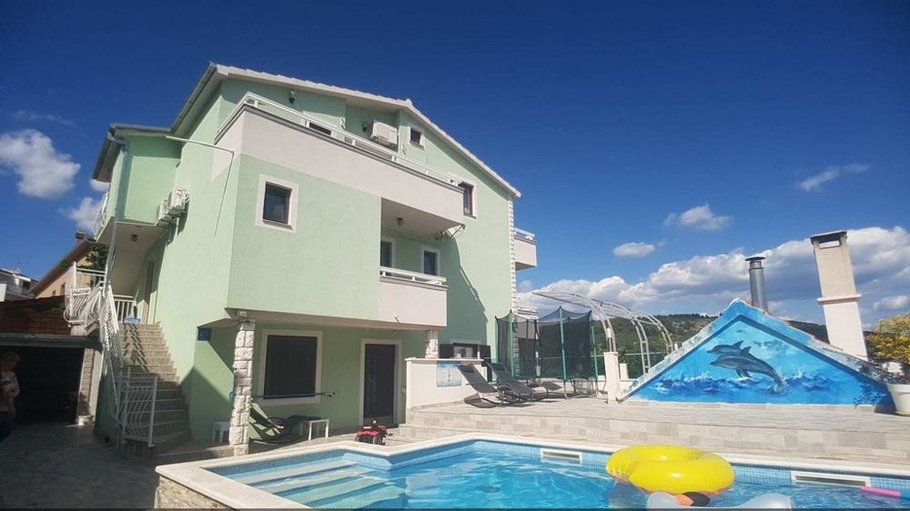 Casa verde con piscina e copertura della piscina nel cortile