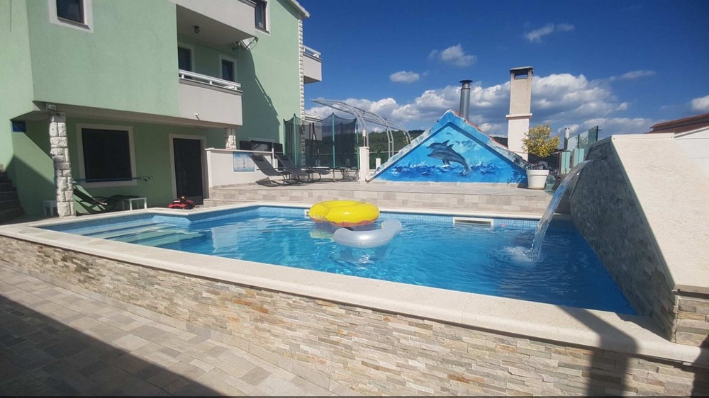 Vista dalla zona relax sulla piscina e sul retro della casa