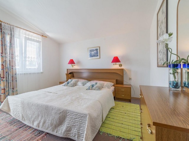 Una camera da letto luminosa con letto matrimoniale e finestra nella zona di Zadar.