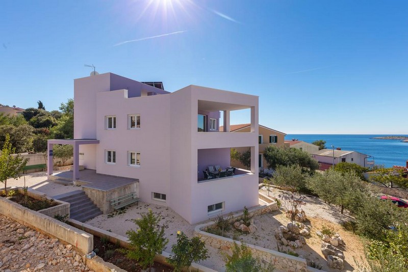 Casa rosa con logge sopra il giardino di ghiaia