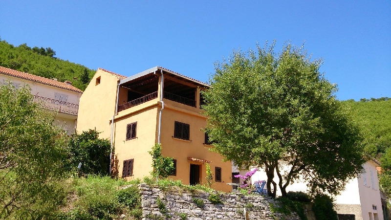 Vista sul retro della casa con il grande balcone coperto - casa in pietra in vendita Croazia.