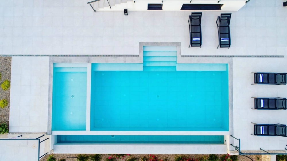 Piscina vista dall'alto con lettini sulla terrazza della piscina