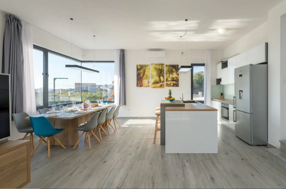 Zona giorno moderna con cucina a vista e zona pranzo.