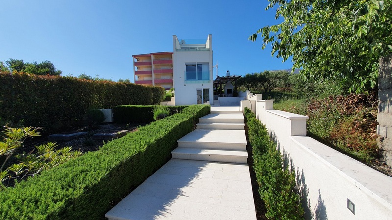 Sentiero a gradini tra siepi potate verso la casa