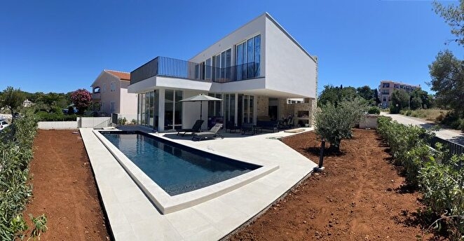 Villa moderna con lunga piscina e ulivo nella terra rossa