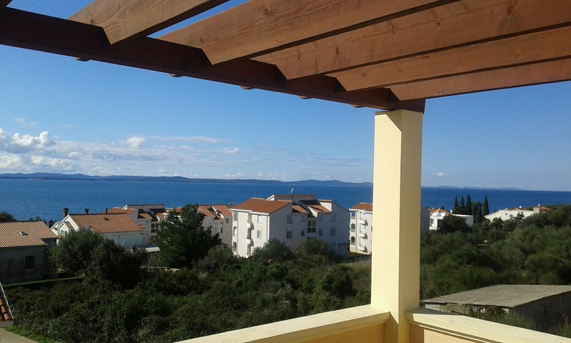Pergola in legno sopra la terrazza con vista sul paese e sul mare