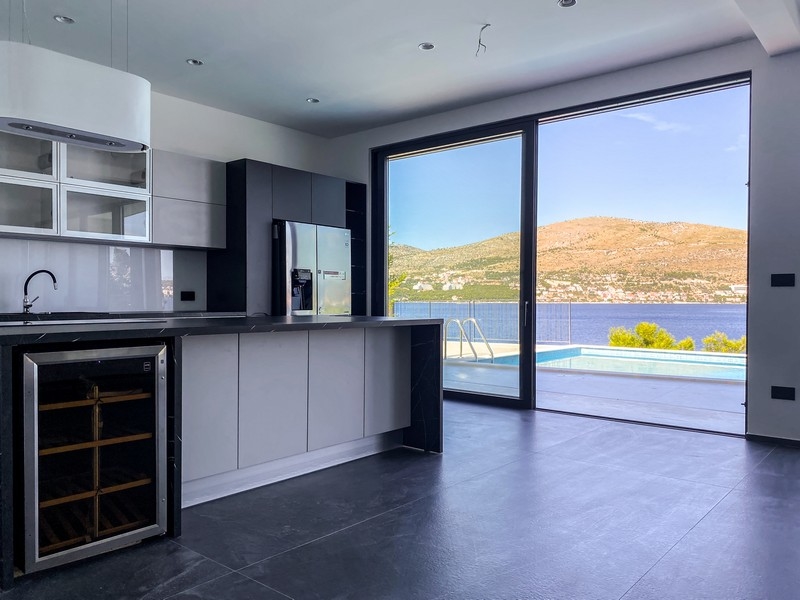 Cucina moderna con vetrata e vista su piscina e mare