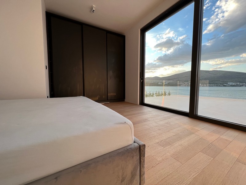 Camera da letto con armadio a muro e finestra a tutta altezza verso il mare