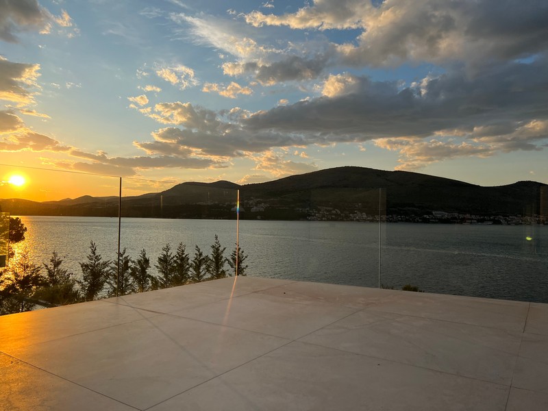 Terrazza con parapetto in vetro al tramonto sopra la baia