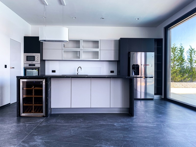 Cucina con isola, cantinetta per il vino e vetrata