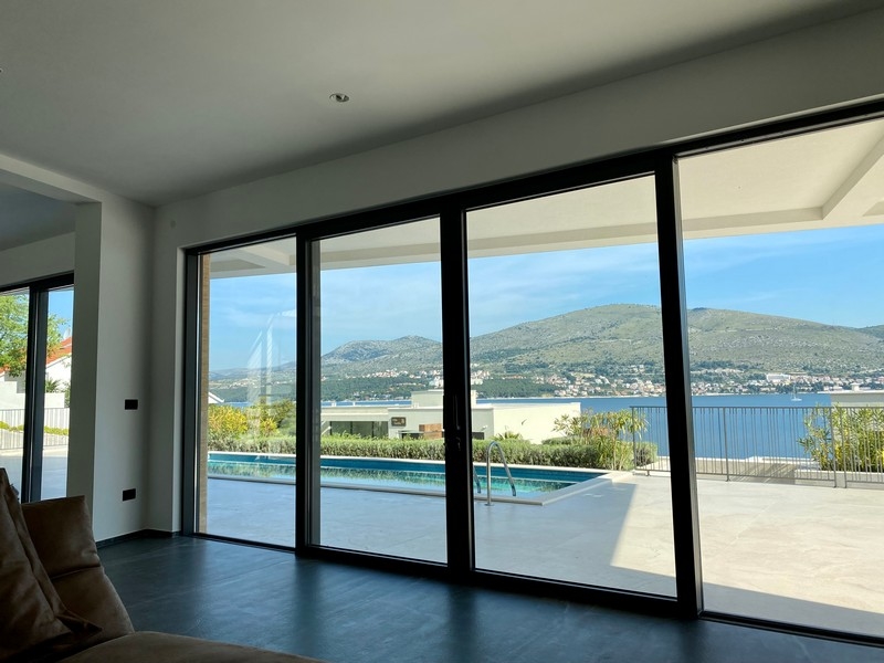 Porte scorrevoli con vista su piscina, baia e montagne