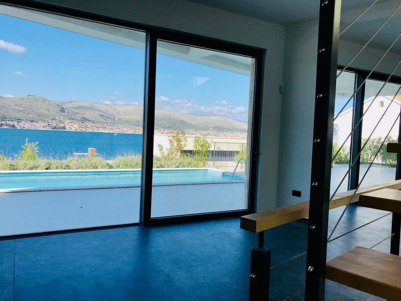 Stanza con vetrata e scala con vista sulla piscina e sulla baia