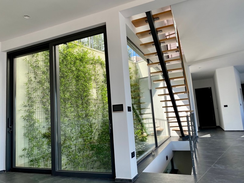 Ingresso con scala in legno aperta e vano luce verde