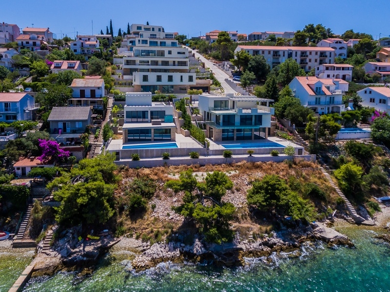 Vista aerea delle ville con piscine sulla costa rocciosa