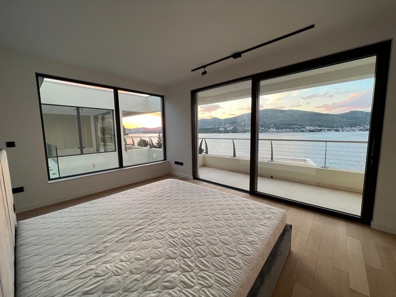 Camera da letto con finestra d'angolo e porta-finestra verso il mare