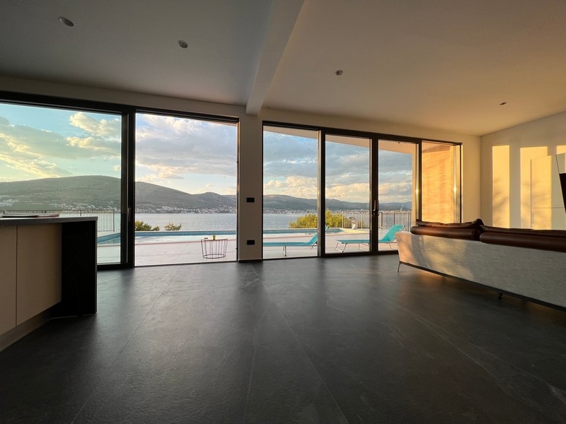 Soggiorno con vetrata e piscina alla luce della sera