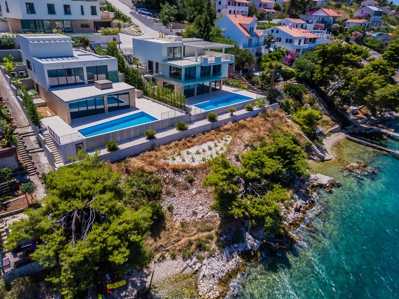 Ripresa aerea di due ville con piscine direttamente sopra l'acqua
