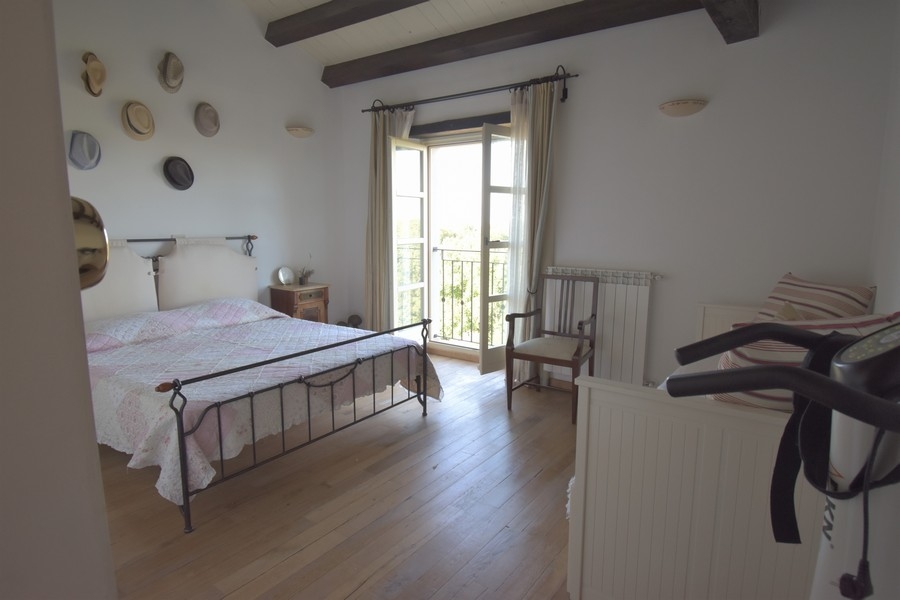 Camera da letto con letto in ferro e cappelli alla parete