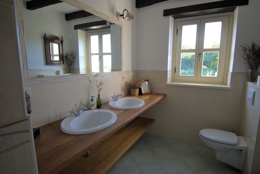 Bagno con due lavabi su un lungo piano in legno