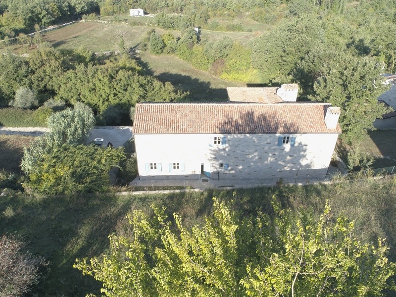 Veduta aerea della casa in pietra con tetto di tegole nel verde