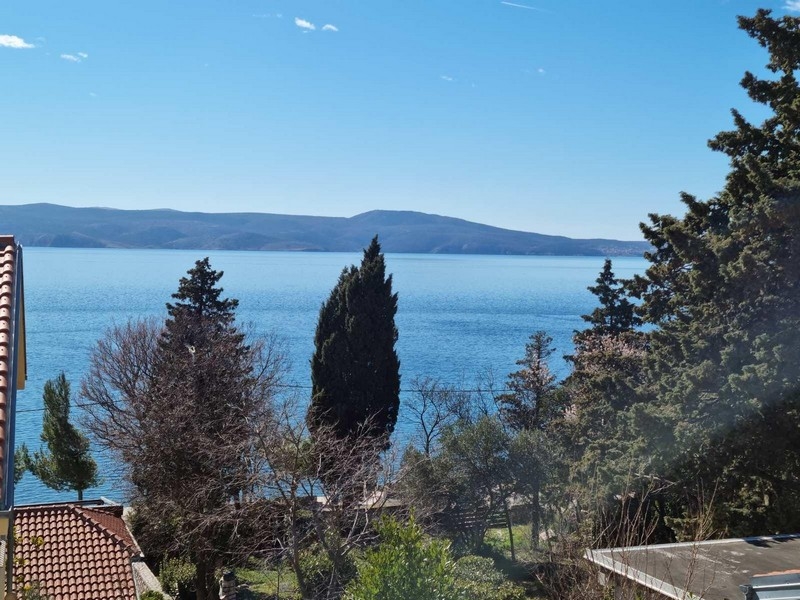 Vista tra i cipressi sul mare e sull'isola di Krk