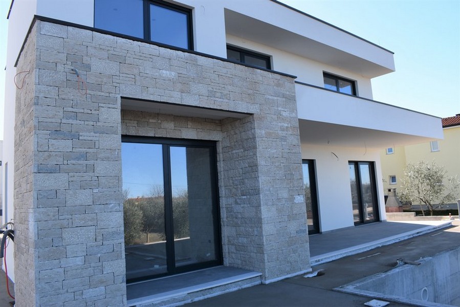 Fronte della casa con rivestimento in pietra naturale intorno all'ingresso
