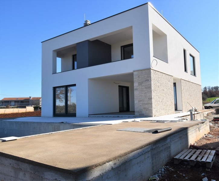 Vista laterale della villa con pietra naturale e terrazza coperta