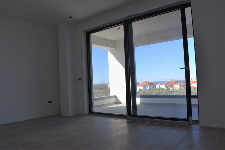 Stanza con ampia porta scorrevole sulla terrazza e vista lontana
