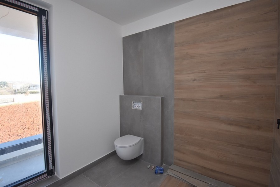 Bagno con parete effetto legno e finestra a tutta altezza
