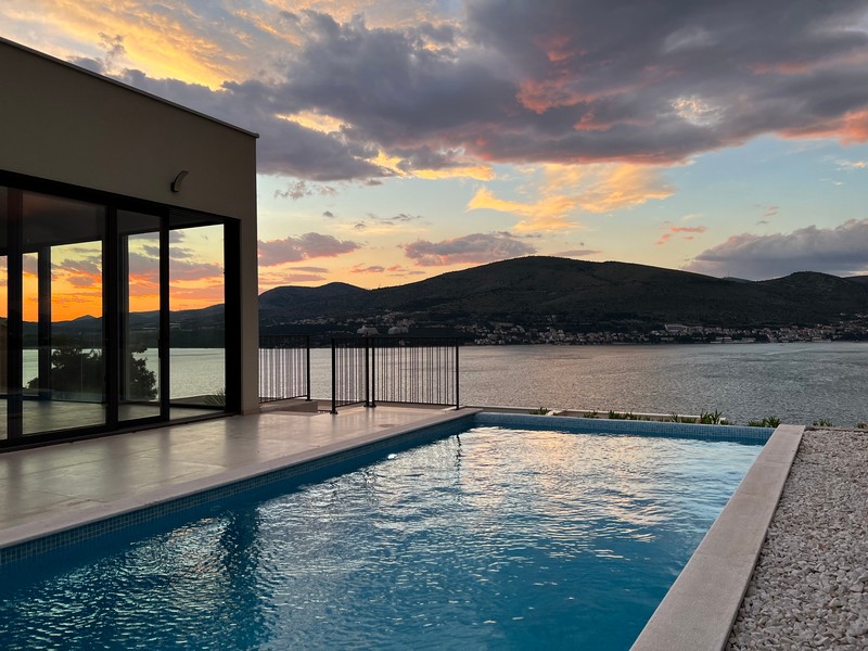 Piscina della casa al tramonto sopra la baia di Trogir