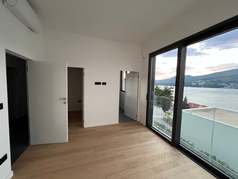 Stanza con parquet e finestra a tutta altezza verso l'acqua