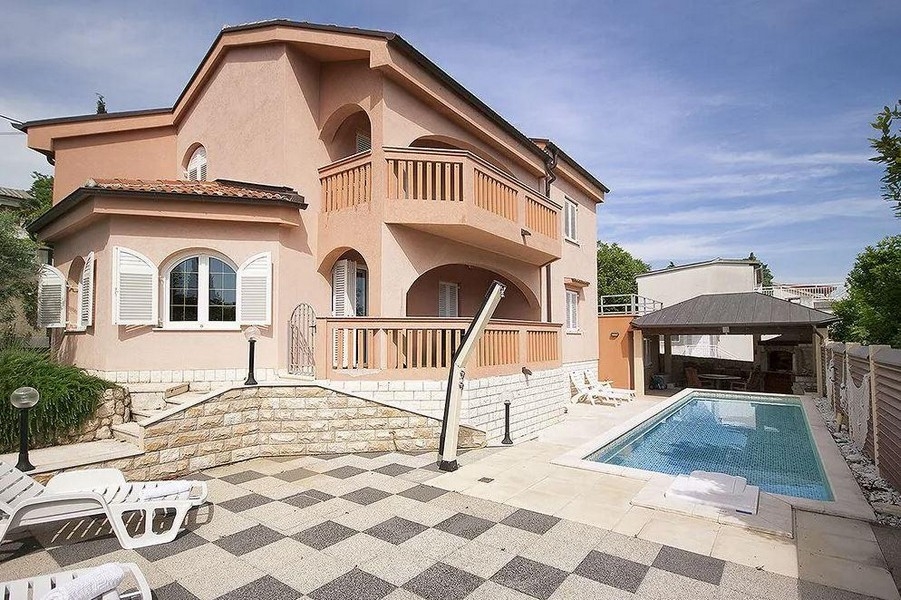 Casa color albicocca con piscina e terrazza piastrellata