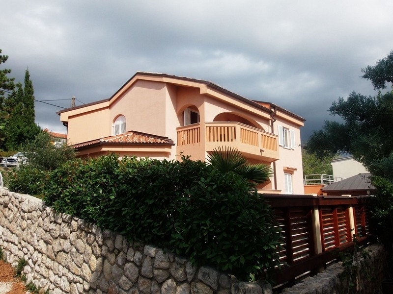 Casa color albicocca con balcone ad arco sopra il muro in pietra naturale