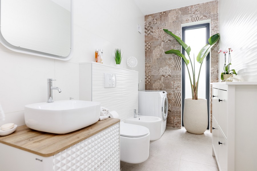 Bagno con lavabo da appoggio e parete piastrellata con motivo