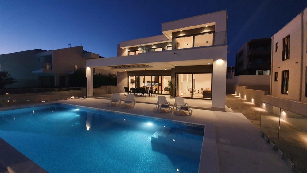 Piscina illuminata davanti alla villa al crepuscolo