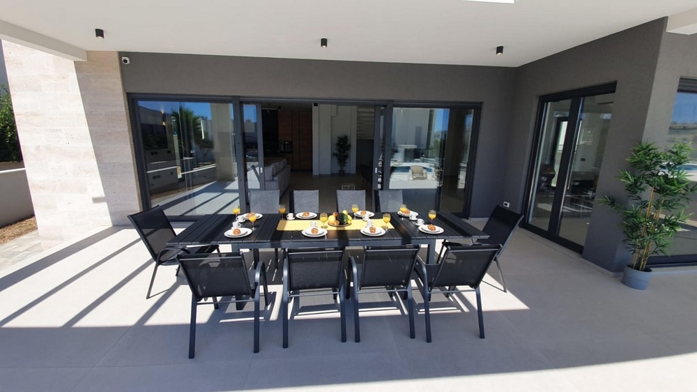Terrazza moderna con zona pranzo coperta.