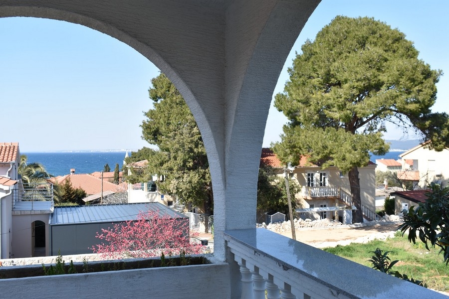 Vista attraverso l'arco della loggia sulla baia e sulle case vicine