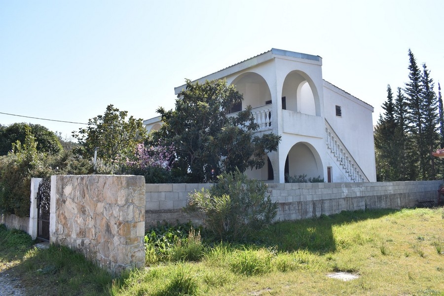 Casa con arcate e scala esterna dietro il muro