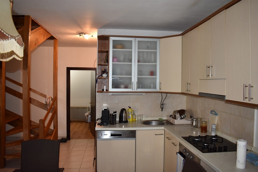 Cucina color crema con scala in legno sullo sfondo