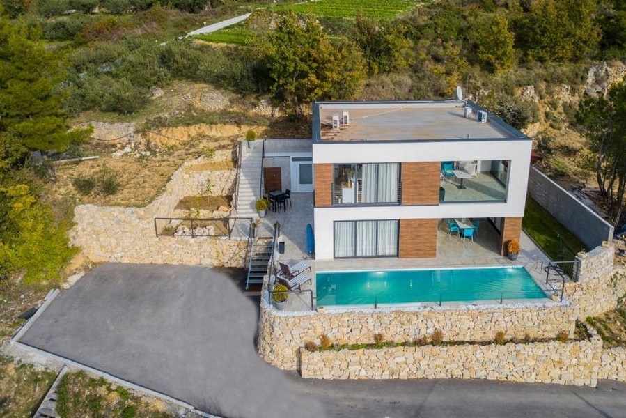 Veduta aerea della villa con piscina sopra il muro a secco